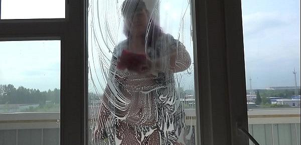  Plump girl in an unbuttoned shirt and in panties washes the window and shakes nice boobs.